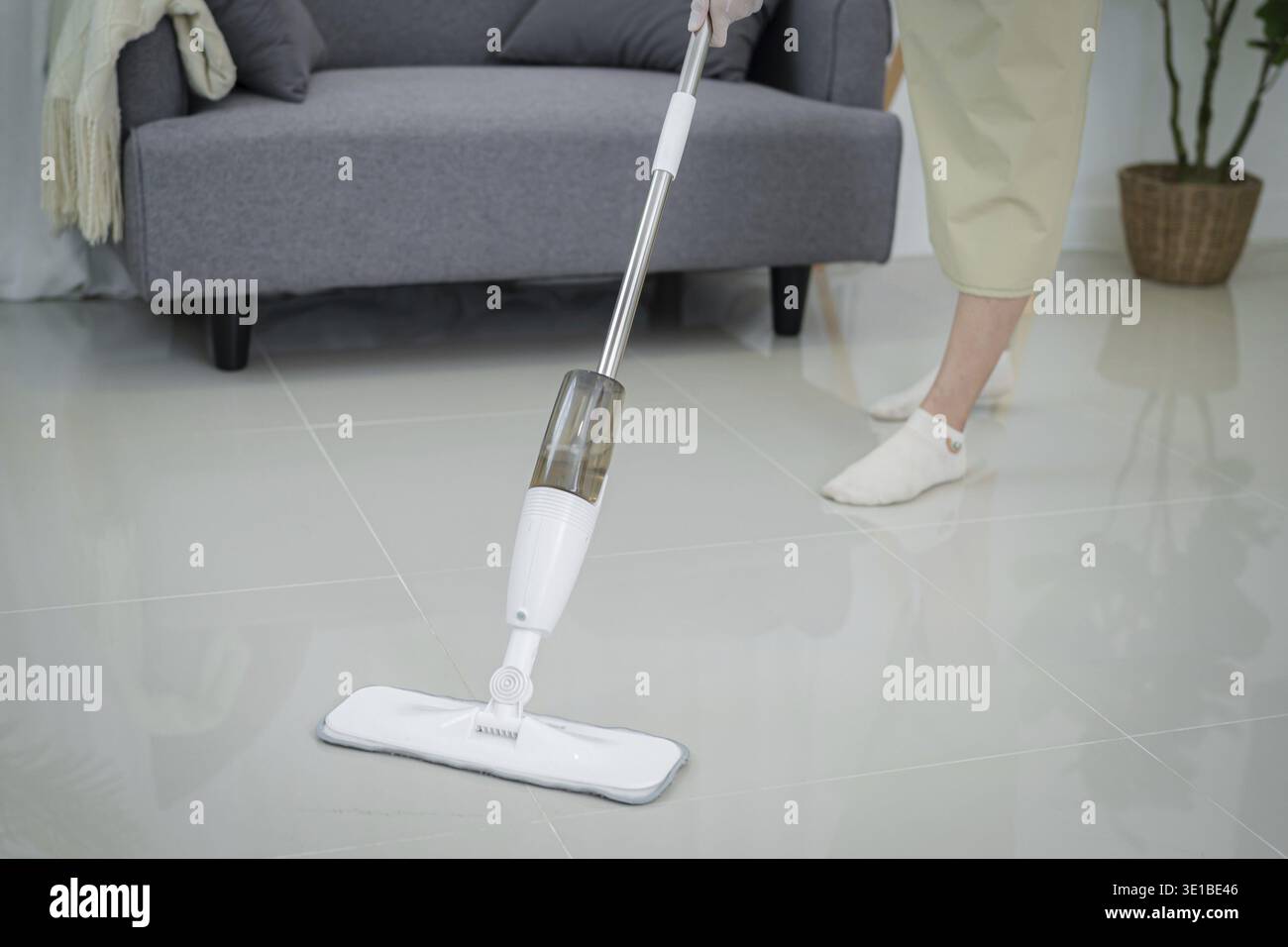 Belle femme asiatique nettoyant le salon dans la maison balayant le sol à l'aide d'un tampon de serpillère humide en microfibre. routine de nettoyage des devoirs. Entretien domestique Banque D'Images