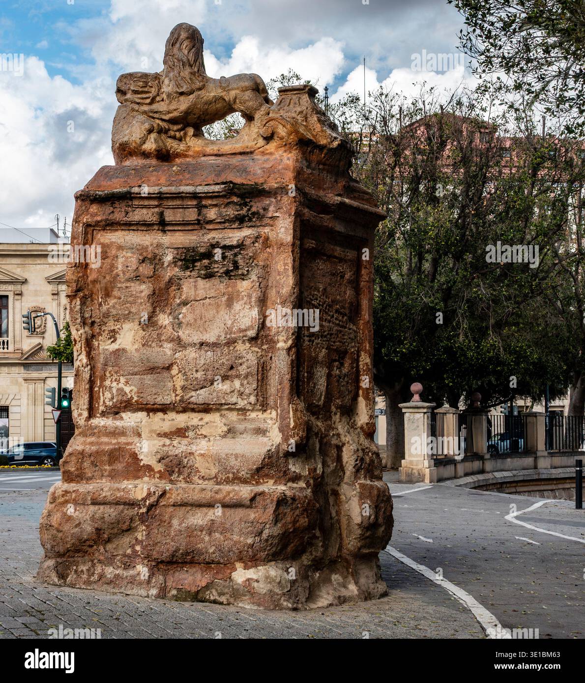 Le Lion de pierre du Puente Viejo à Murcie, Espagne. Une sculpture de lion altérée sur un piédestal en pierre massif gardant le vieux pont historique. Banque D'Images