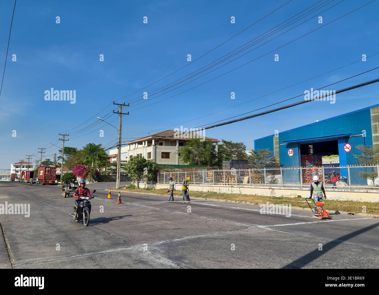 Travaux d'entretien d'infrastructures ou de marquage routier dans une zone industrielle suburbaine de Phnom Penh SEZ (PPSEZ), Cambodge, Asie Banque D'Images