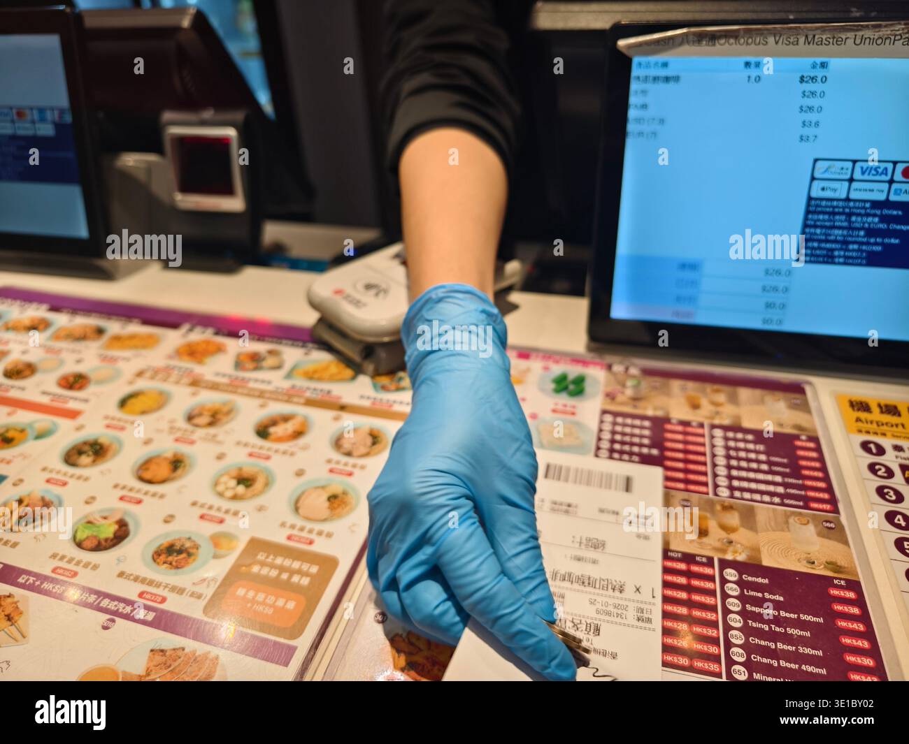 Personnel du café remettant les pièces de monnaie et les reçus portant des gants bleus en nitrile pour éviter la contamination croisée, café Moon Thai Express, aéroport de Hong Kong, Asie Banque D'Images