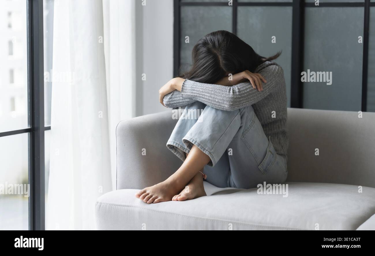 Jeune femme asiatique se sentant seule triste malade stressée sur Sofa at Home Alone pour Healthcare Wellness Lifestyle Banque D'Images