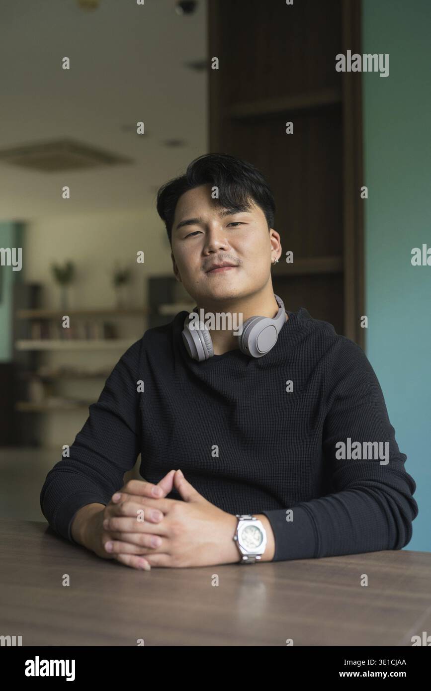 Portrait de beau jeune homme asiatique assis à l'intérieur concept Banque D'Images