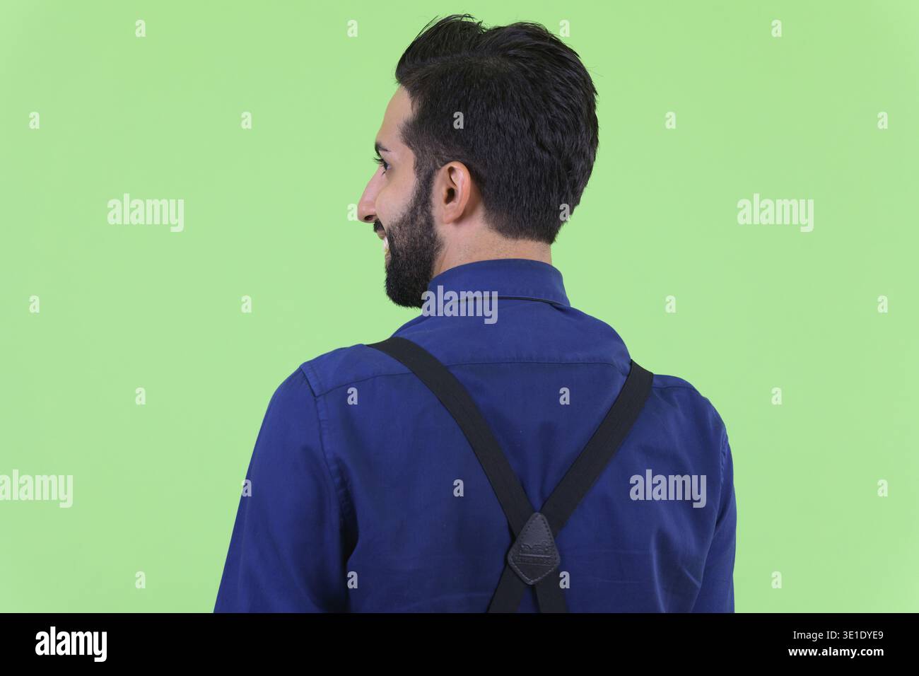 Studio shot du jeune bel homme d'affaires perse barbu sur fond vert Banque D'Images