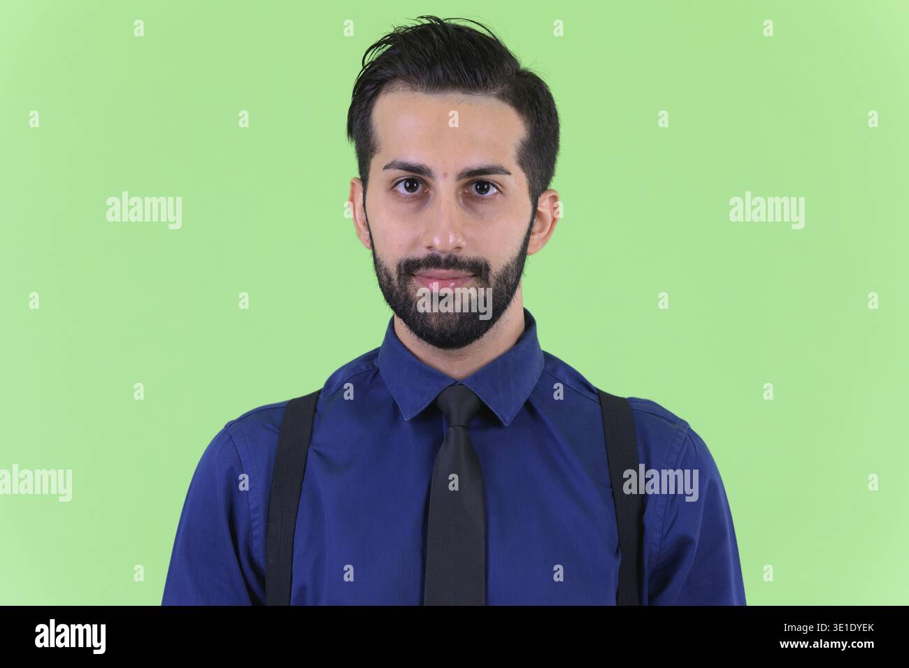 Studio shot du jeune bel homme d'affaires perse barbu sur fond vert Banque D'Images
