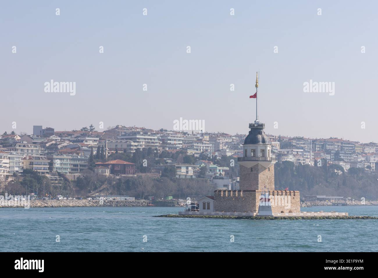 Monument historique Maiden Tower au milieu du détroit du Bosphore, Istanbul, avec l'horizon de la ville en arrière-plan par une journée ensoleillée. Banque D'Images