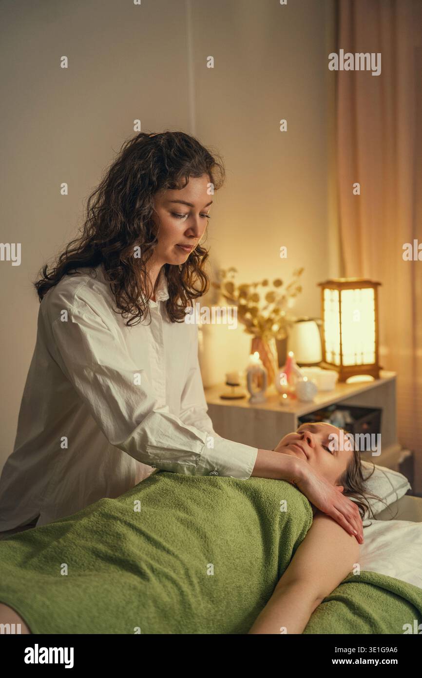 Thérapeute professionnel effectuant un massage des épaules dans un spa relaxant. Banque D'Images