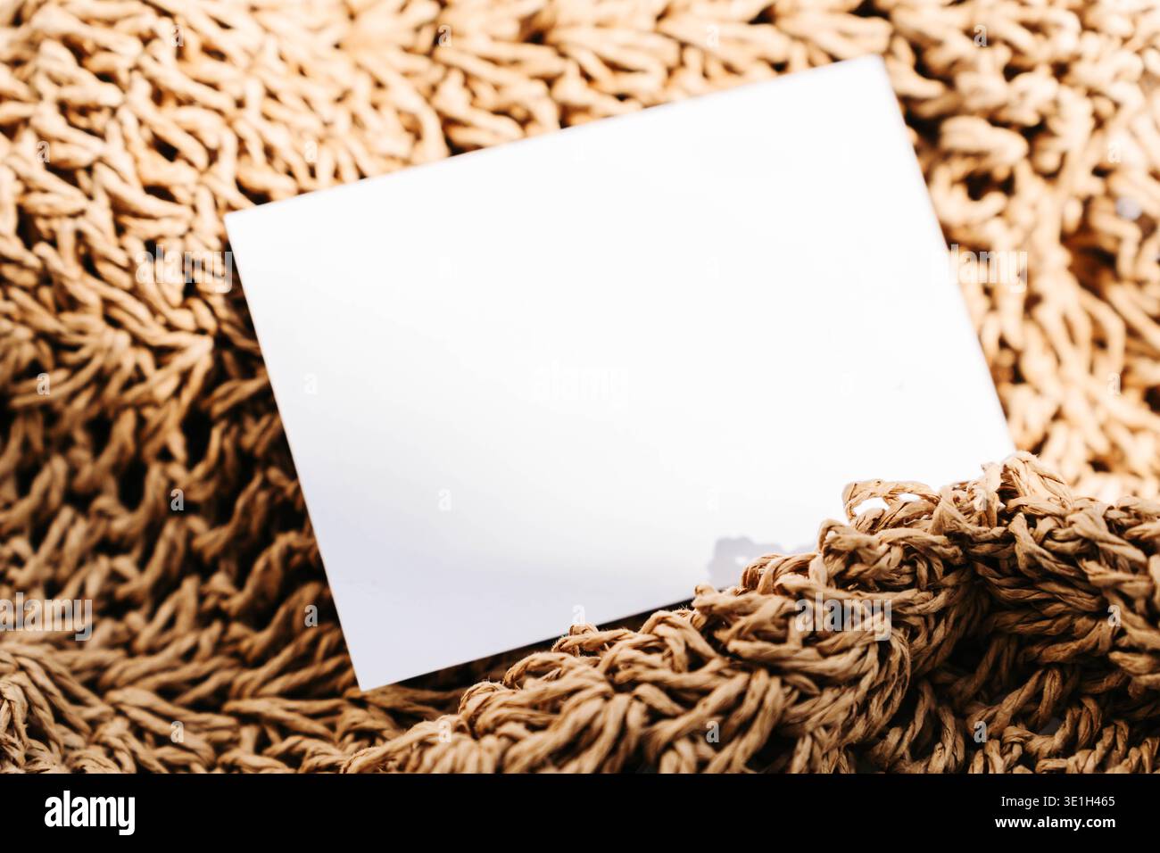 Carte de visite blanche vierge sur fond de tissu naturel texturé. Maquette de marque minimale avec tons chauds et espace de copie pour logo, identité ou design Banque D'Images