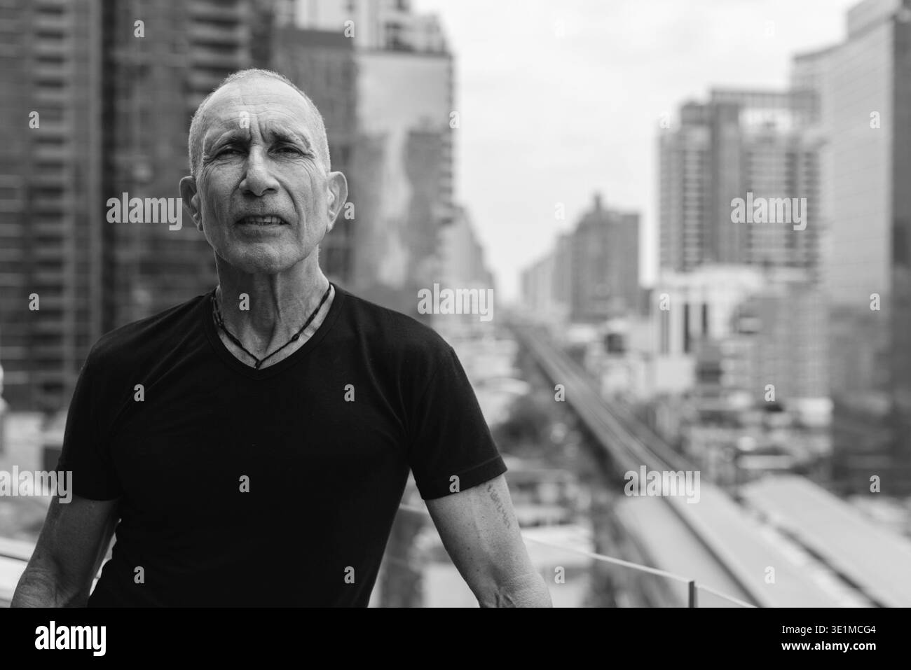 Portrait d'un homme âgé chauve explorant la ville à l'extérieur noir et blanc Banque D'Images