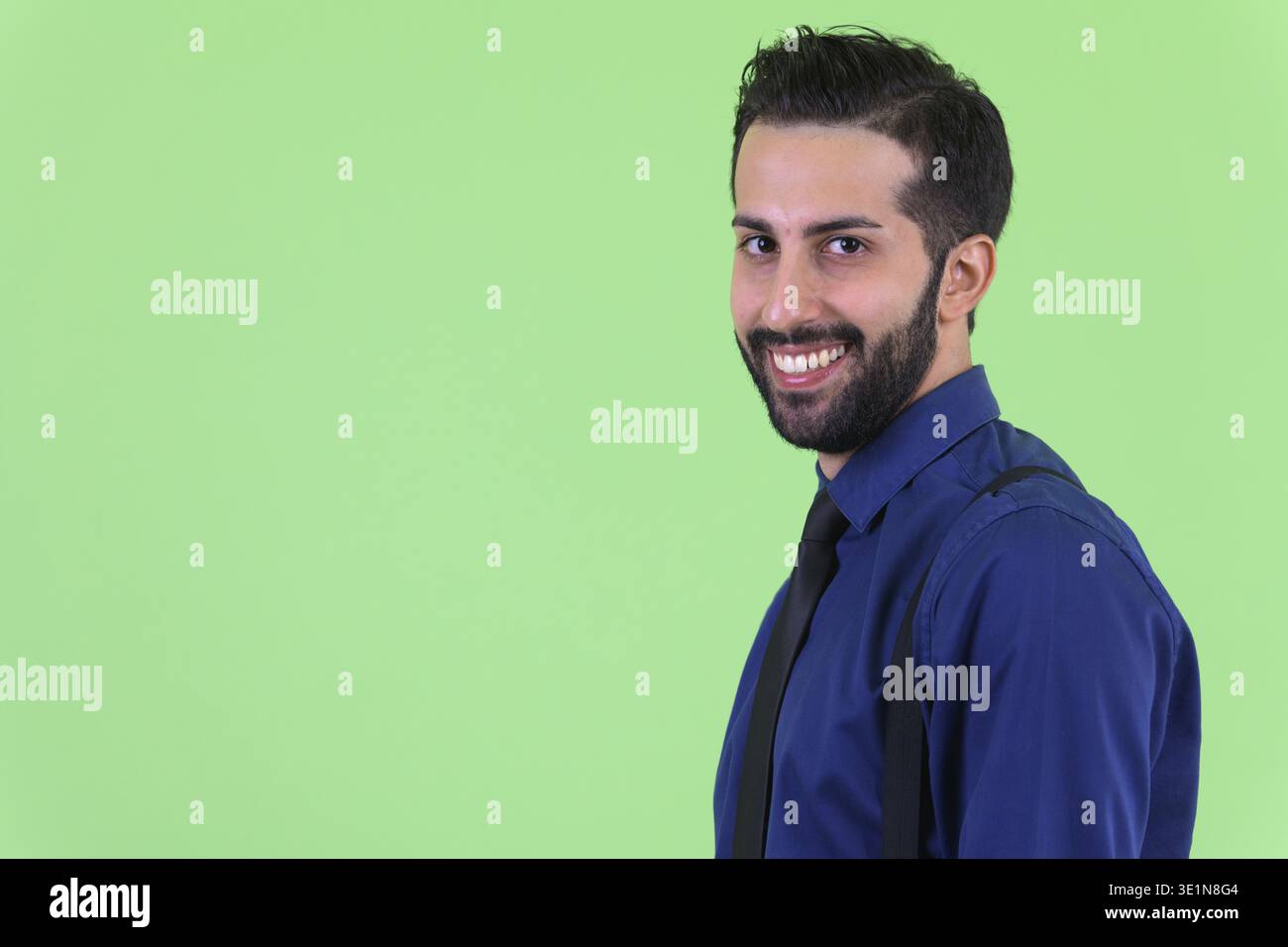 Studio shot du jeune bel homme d'affaires perse barbu sur fond vert Banque D'Images