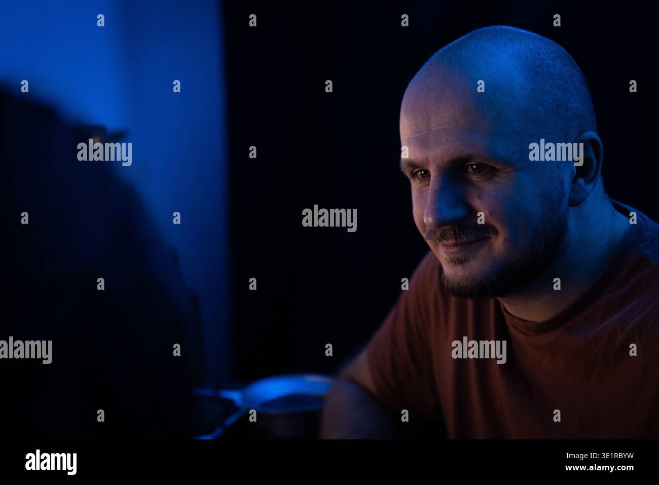 Portrait d'un homme souriant dans Blue Light Banque D'Images