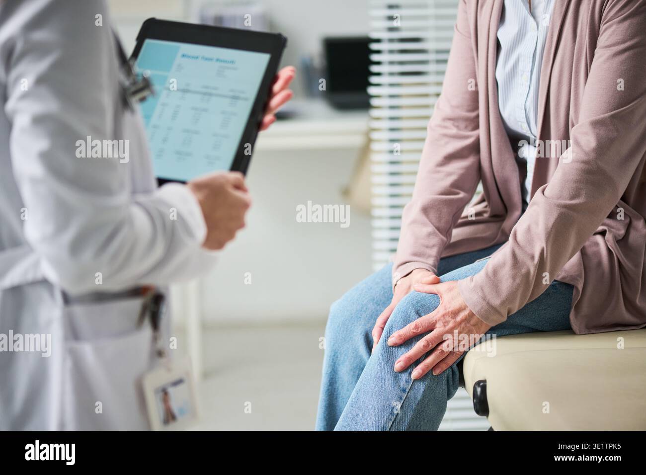 Femme adulte consultant médecin au sujet de la douleur au genou dans la clinique Banque D'Images