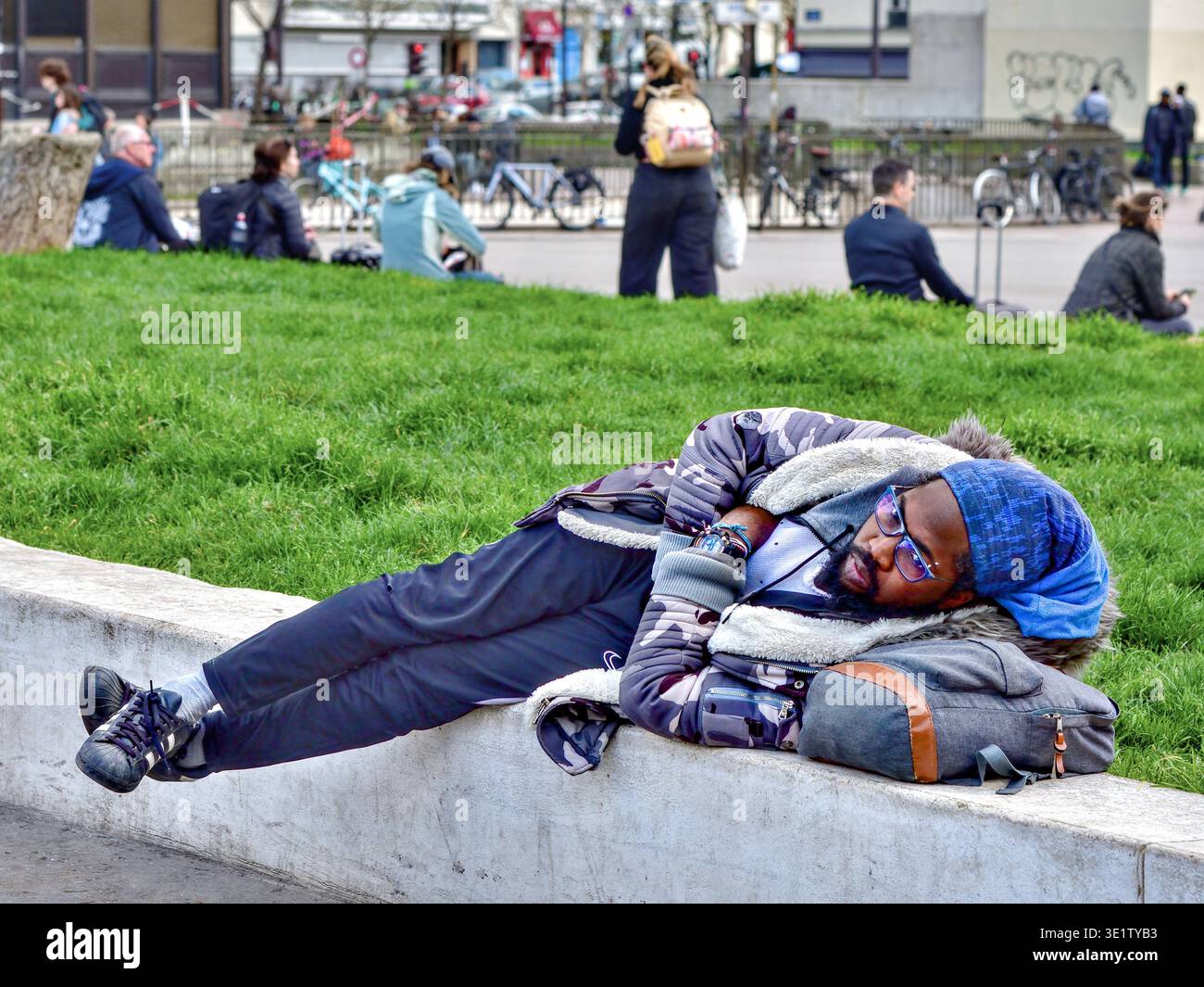 Noir Français Africain couché sur le mur de la ow à l'extérieur de la gare ferroviaire internationale Gare Montparnasse - Paris 75015, France. Banque D'Images