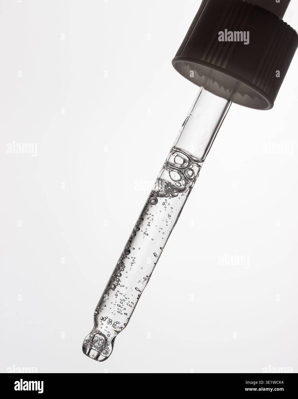 Compte-gouttes de sérum transparent avec bulles en gros plan Banque D'Images