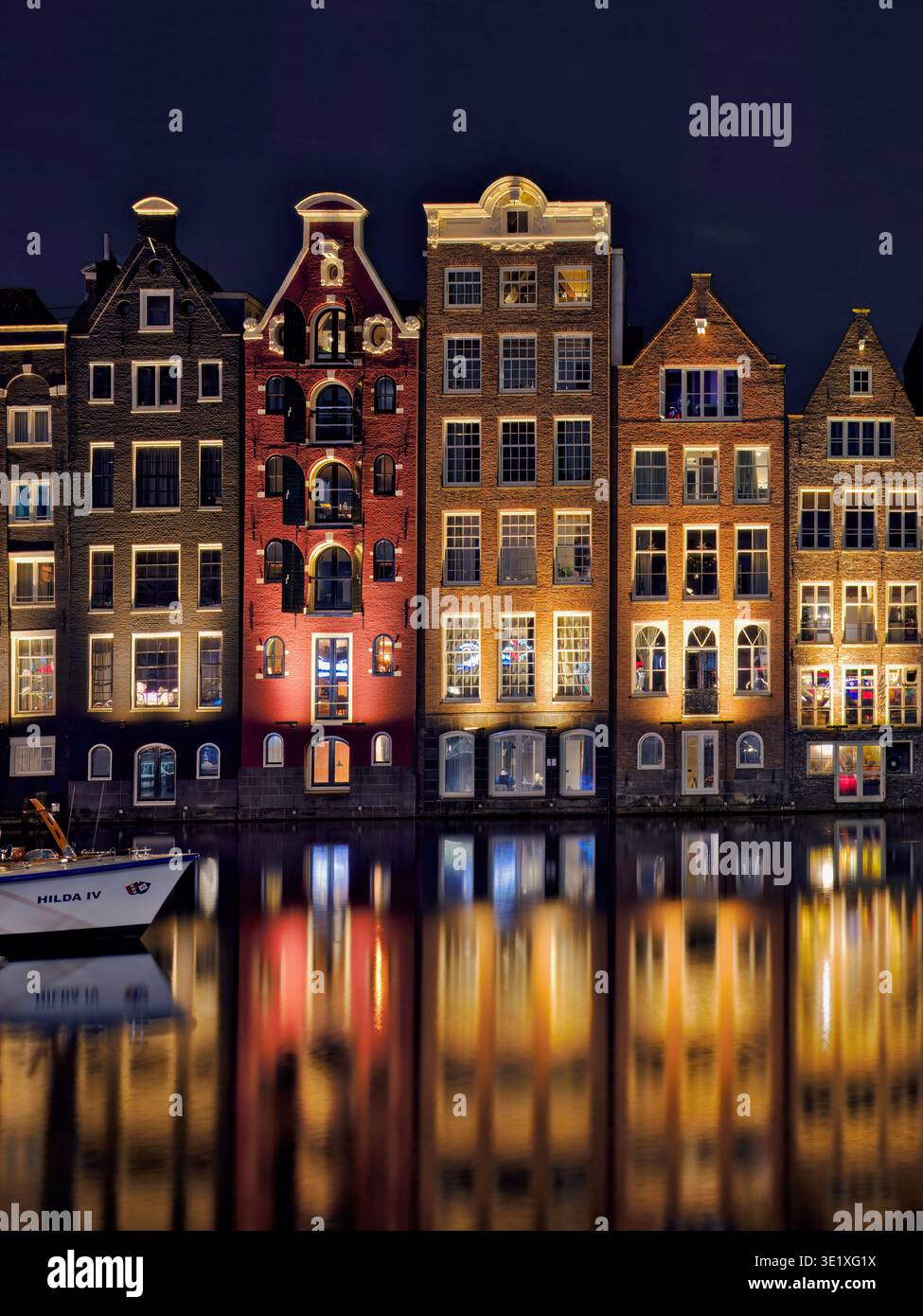 Les maisons Damrak à Amsterdam, aux pays-Bas, créant un kaléidoscope de couleurs et de reflets vibrants. Banque D'Images