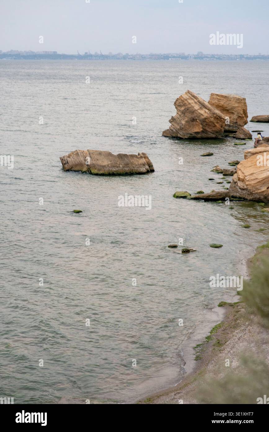 Paysage marin calme avec de grands rochers dans l'eau près d'une plage de sable. Concept de beauté de la nature maritime, atmosphère d'été paisible, et tranquille Banque D'Images