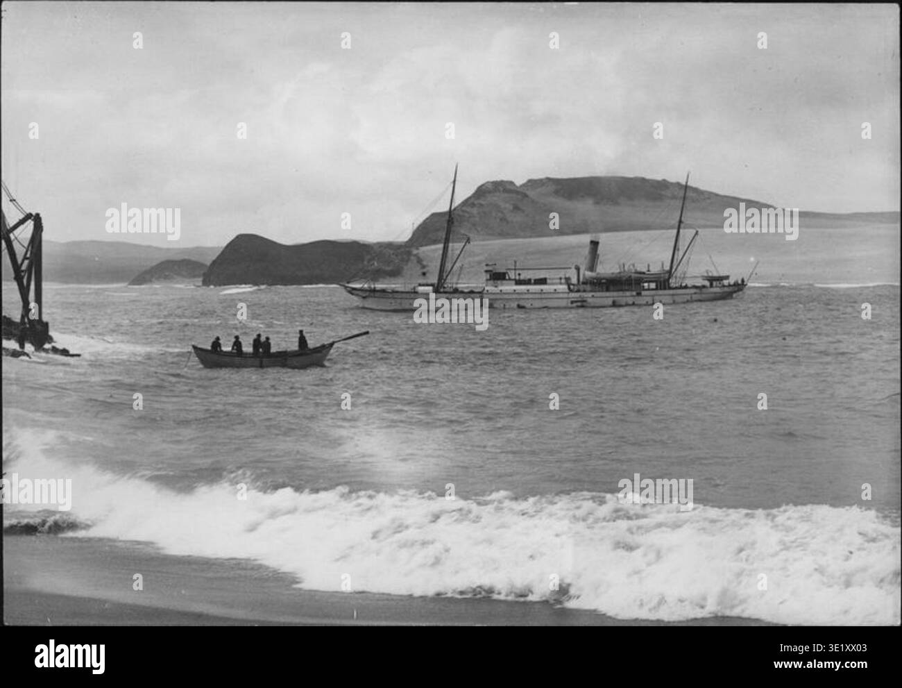 Cape Maria van Diemen, situé à la pointe nord de l’île du Nord de la Nouvelle-Zélande, est représenté sur cette photographie de la croisière *Hinemoa* de 1902. L'image montre le bateau *Hinemoa* et son équipage, illustrant la vie maritime du début du XXe siècle et le rôle critique des phares dans la navigation côtière néo-zélandaise. Banque D'Images