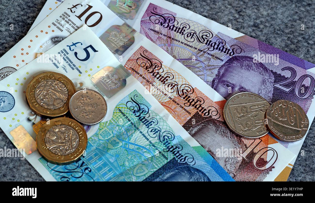 Billets de banque du roi Charles III de la Banque d'Angleterre avec des pièces britanniques montrés en gros plan comme un concept de monnaie britannique et de finances personnelles Banque D'Images