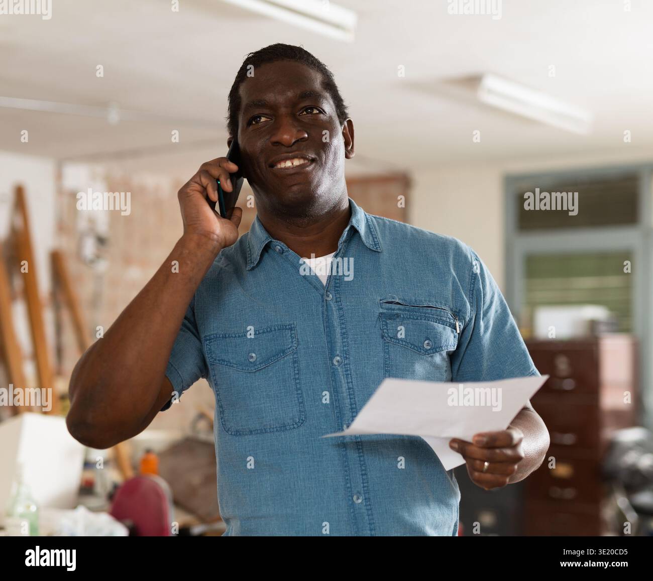 Homme ayant une conversation téléphonique dans le chantier de construction Banque D'Images