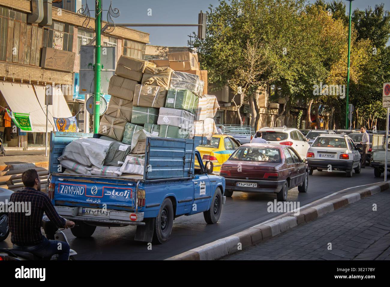 ISPAHAN, IRAN - 8 AOÛT 2016 : pick-up surchargé empilé avec des colis liés conduit dans la circulation de rue à Ispahan, Iran, montrant des marchandises informelles tr Banque D'Images