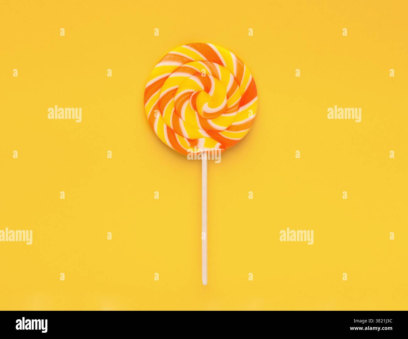 Sucette de bonbons en spirale sur fond jaune, vue de dessus Banque D'Images