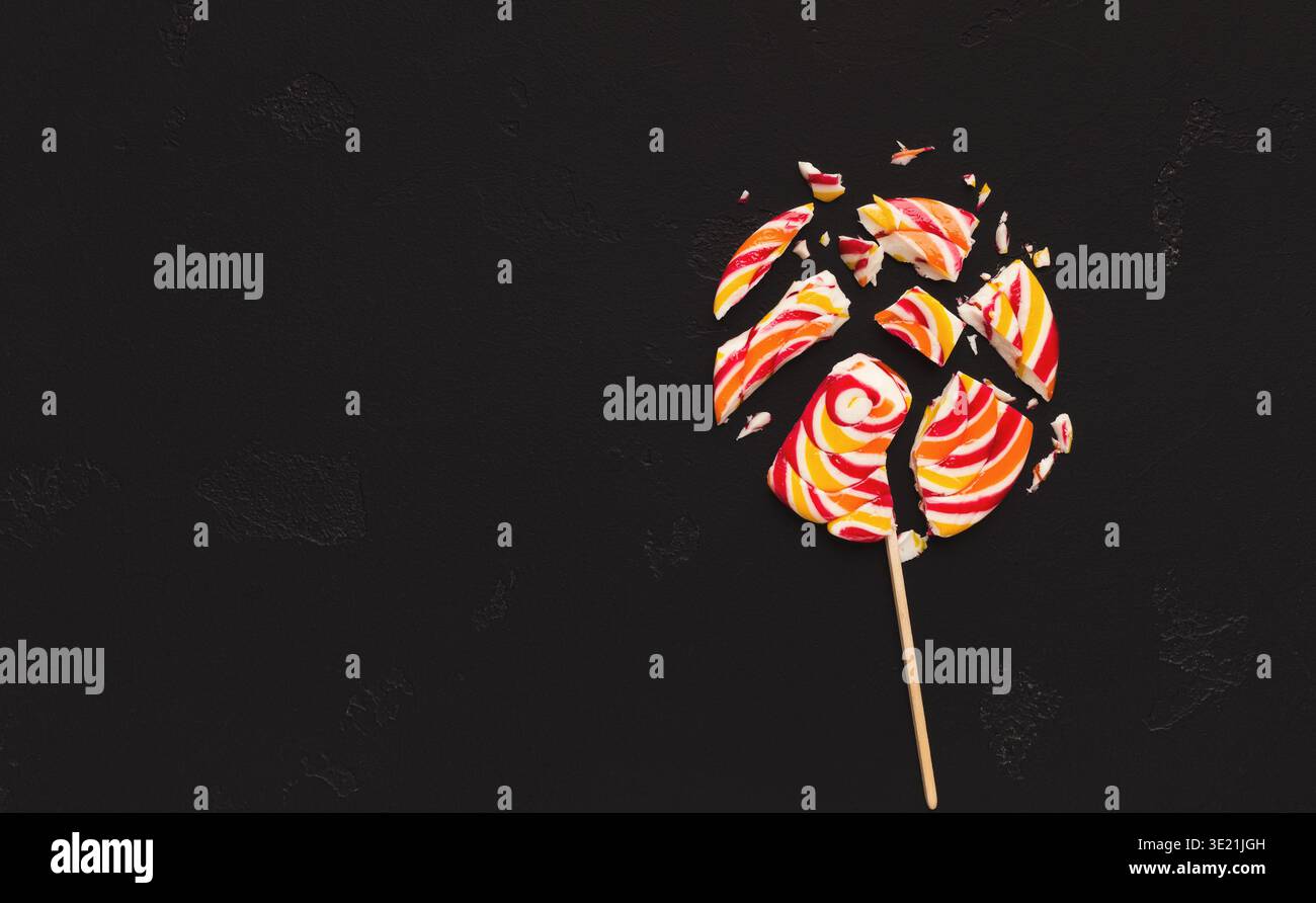 Bonbons sucettes écrasés sur fond noir Banque D'Images