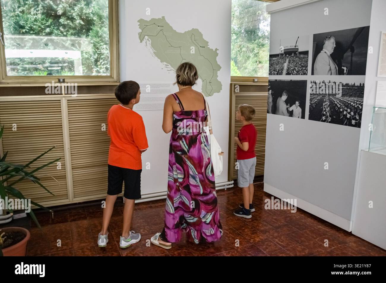 Famille explorant l'histoire yougoslave : carte de SFRJ et photos de Josip Broz Tito au Musée de Yougoslavie Banque D'Images