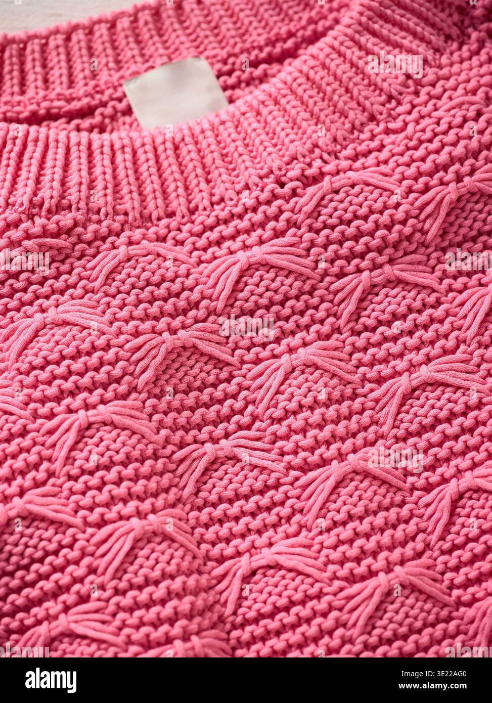 Pull en maille rose avec motifs texturés complexes et col côtelé. Allemagne Banque D'Images