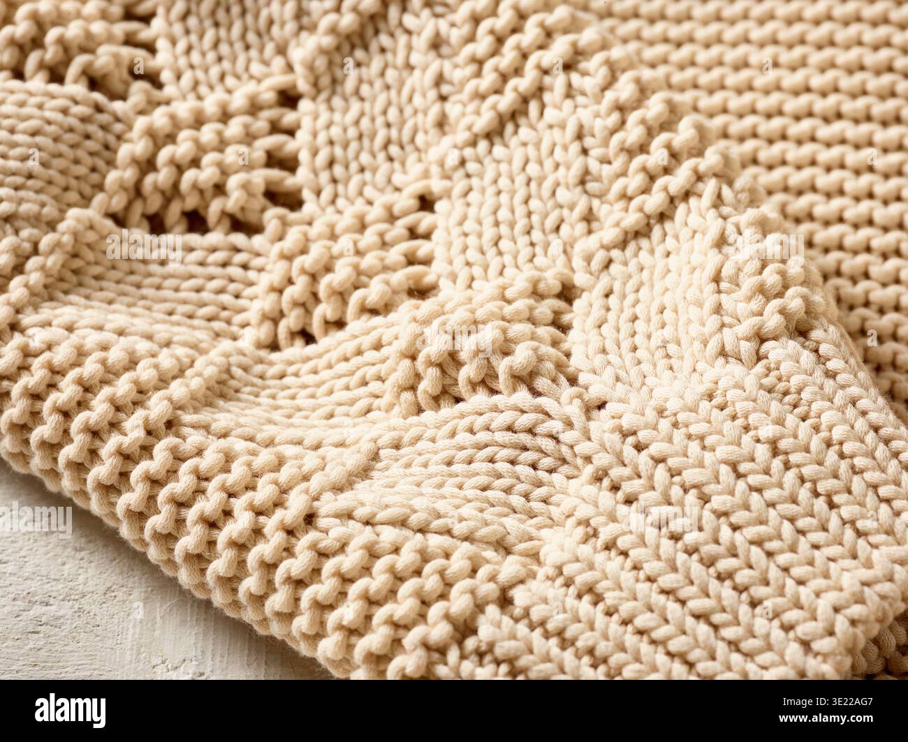 Gros plan de tricot beige détaillé avec motif texturé sur fond clair. Allemagne Banque D'Images