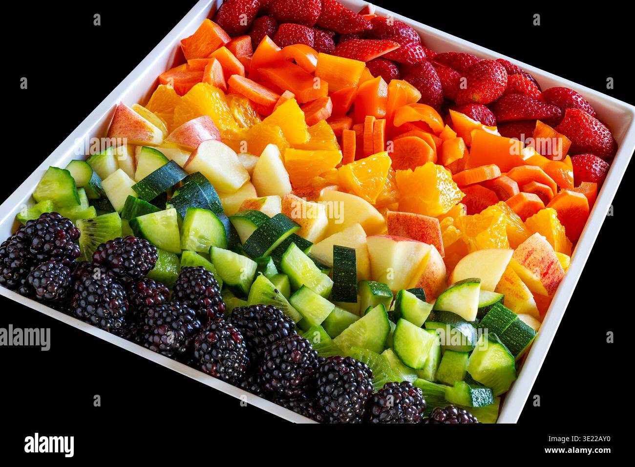 Arrangement coloré de fruits et légumes frais sur un plateau blanc carré. Banque D'Images