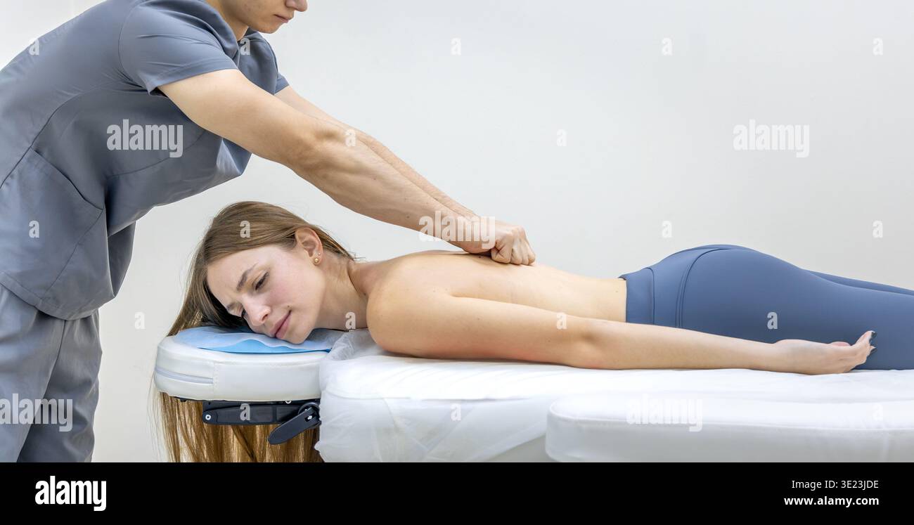 Le médecin de réadaptation applique une contre-pression profonde à la patiente en clinique. Déclencher le travail. Banque D'Images