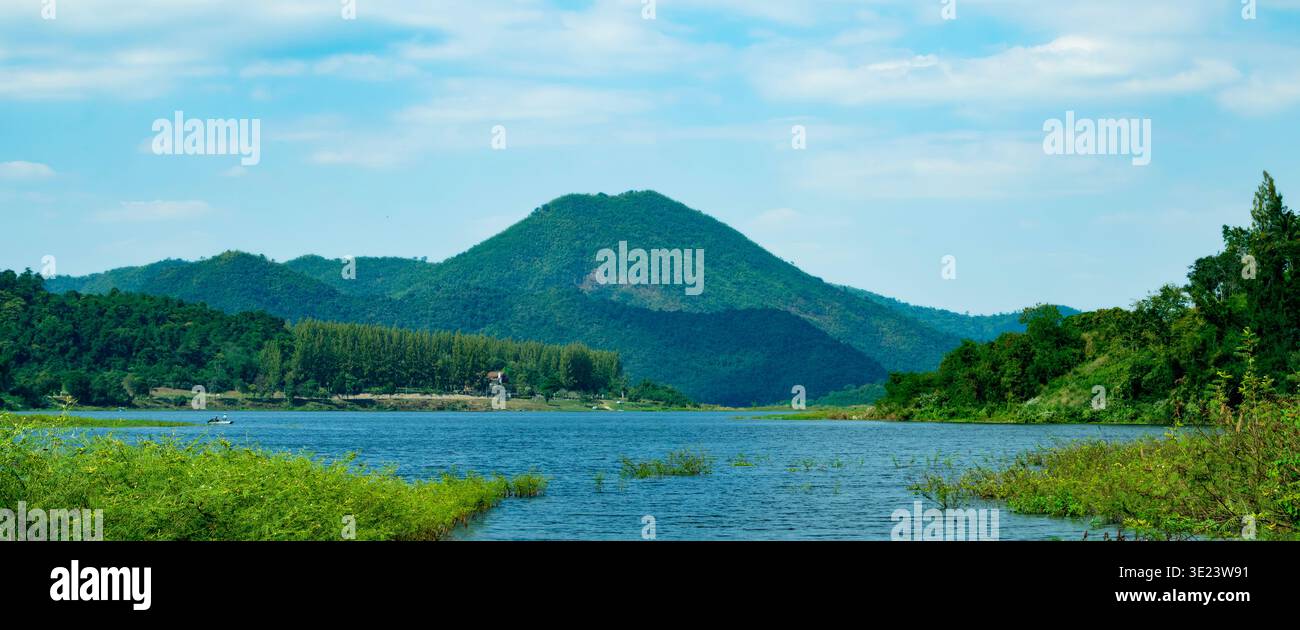 Vue panoramique à couper le souffle sur des montagnes verdoyantes s'élevant au-dessus d'un lac bleu serein et d'une forêt Banque D'Images