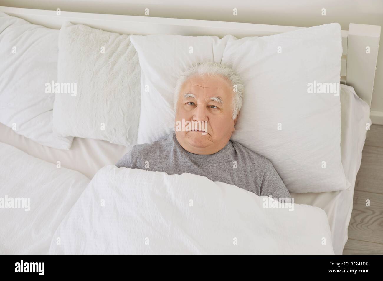Homme âgé atteint de troubles du sommeil insomniques couché dans son lit regardant le plafond Banque D'Images