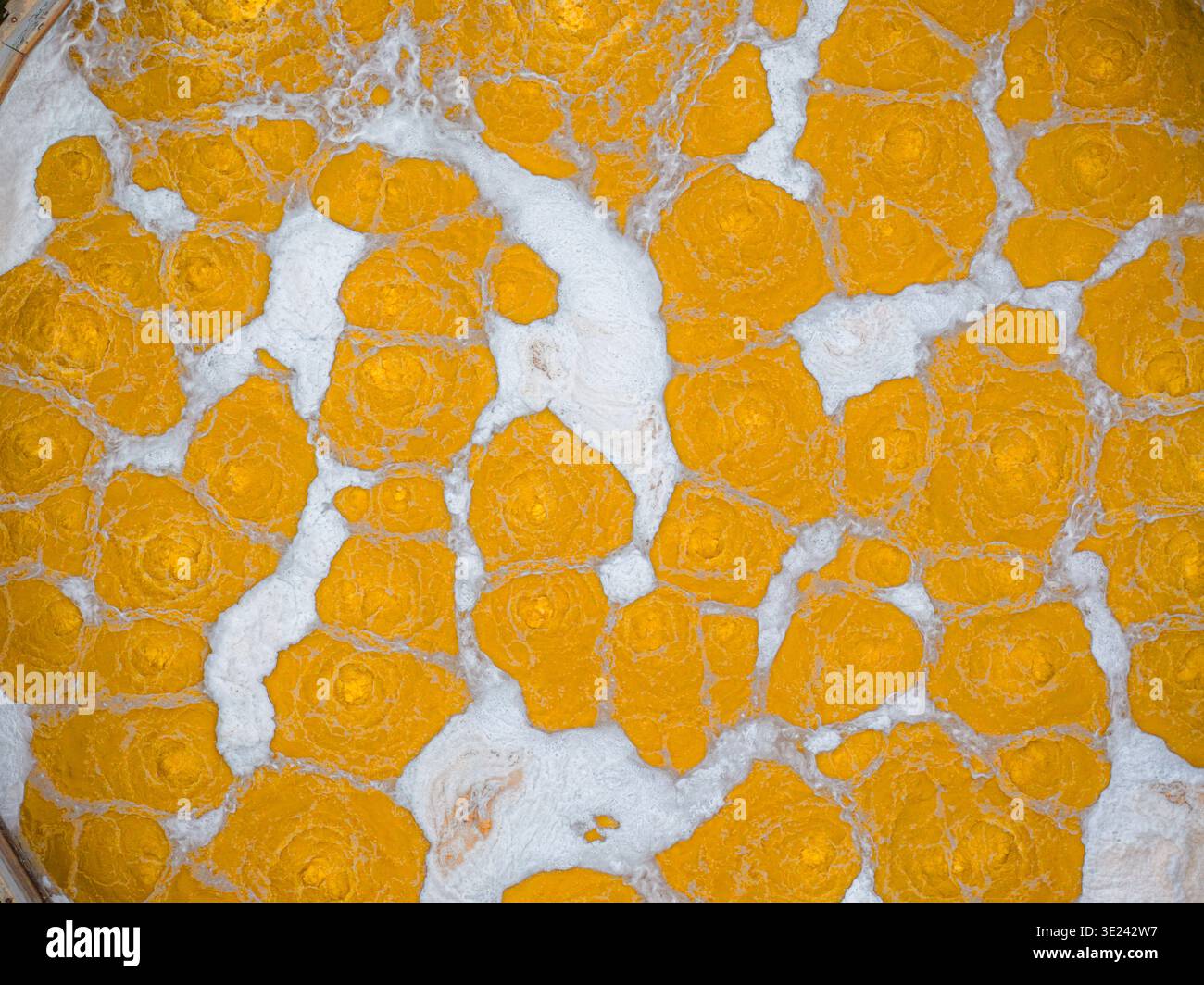 Vue aérienne d'une mosaïque envoûtante de teintes dorées fracturées par des veines de blanc dur, créant un paysage abstrait qui captive l'œil., Avezzan Banque D'Images