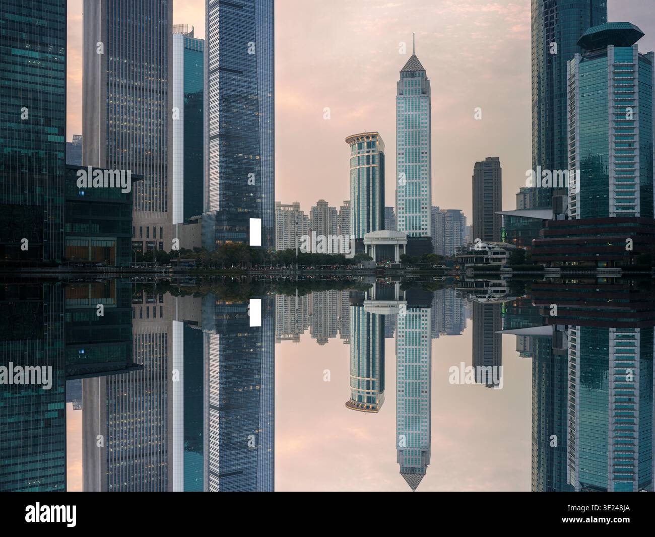Composition symétrique frappante montrant un horizon moderne du centre-ville avec des gratte-ciels en verre illuminés reflétant parfaitement dans un environnement parfaitement encore urbain Banque D'Images