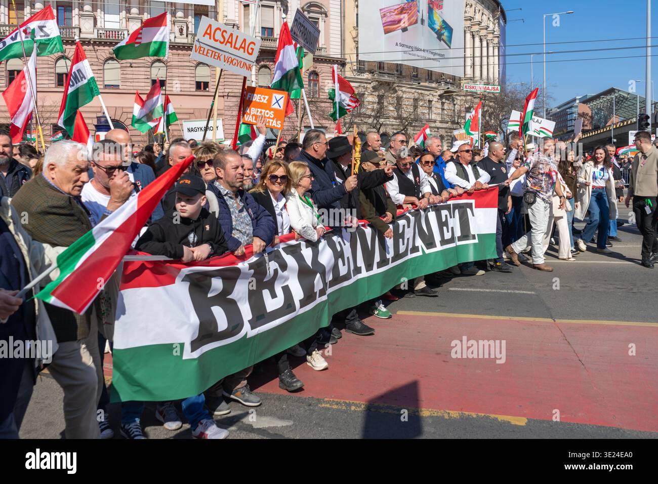 La foule marche avec une grande bannière « marche pour la paix » et des drapeaux hongrois lors d’une manifestation pro-gouvernementale en faveur du Fidesz à Budapest. Banque D'Images