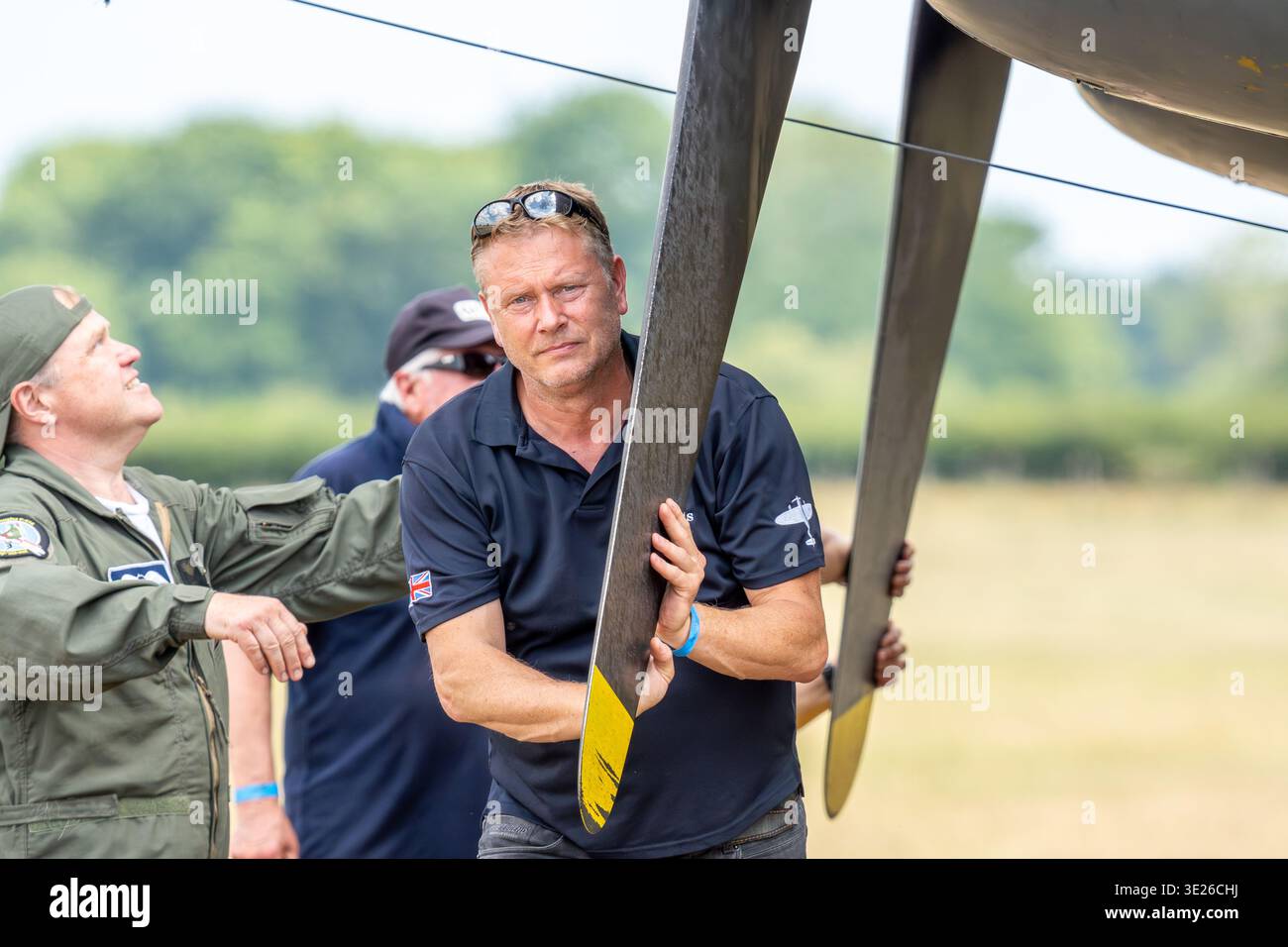 Headcorn Battle of Britain Airshow - Une équipe de mécaniciens aéronautiques inspecte et manipule de grandes pales d'hélice lors d'un spectacle aérien extérieur, montrant concent Banque D'Images