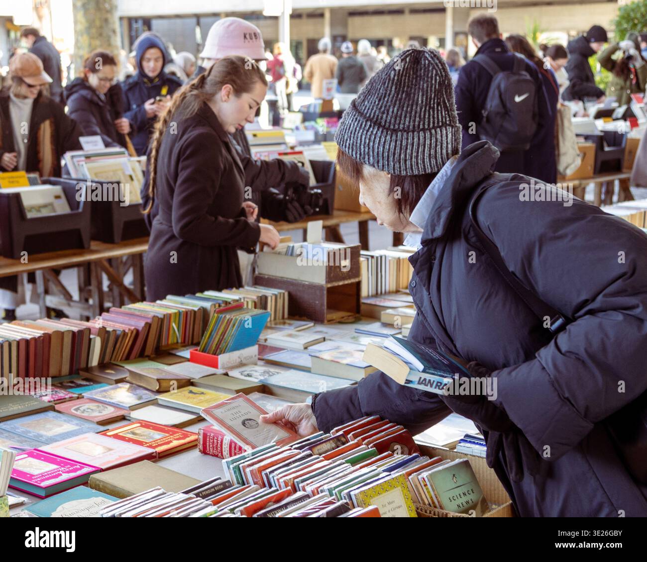 Les gens sélectionnent des livres à partir de tables au marché extérieur de la rive sud à Londres Banque D'Images