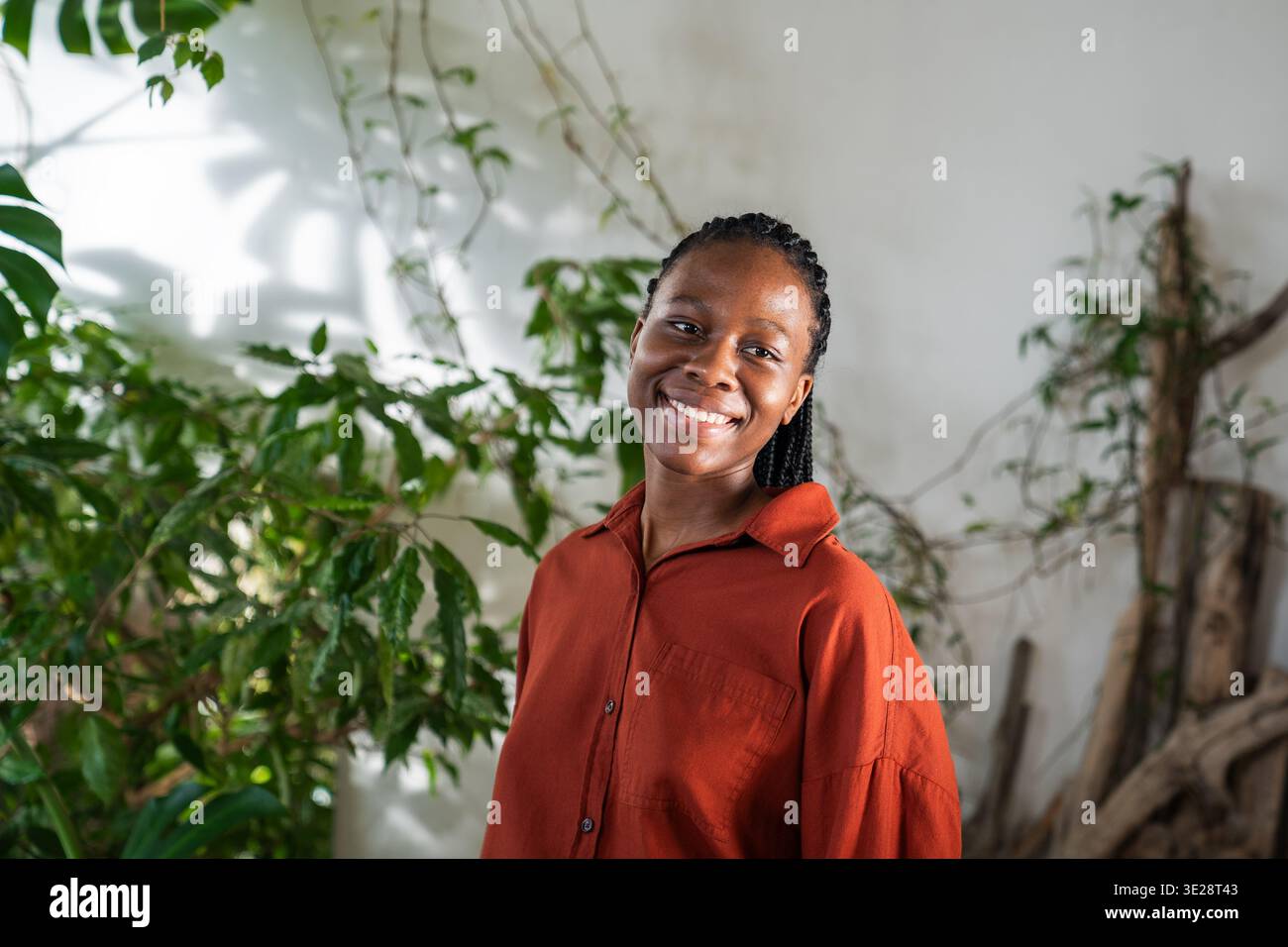 Femme afro-américaine confiante positive dans le jardin à la maison avec une expression optimiste souriante. Banque D'Images