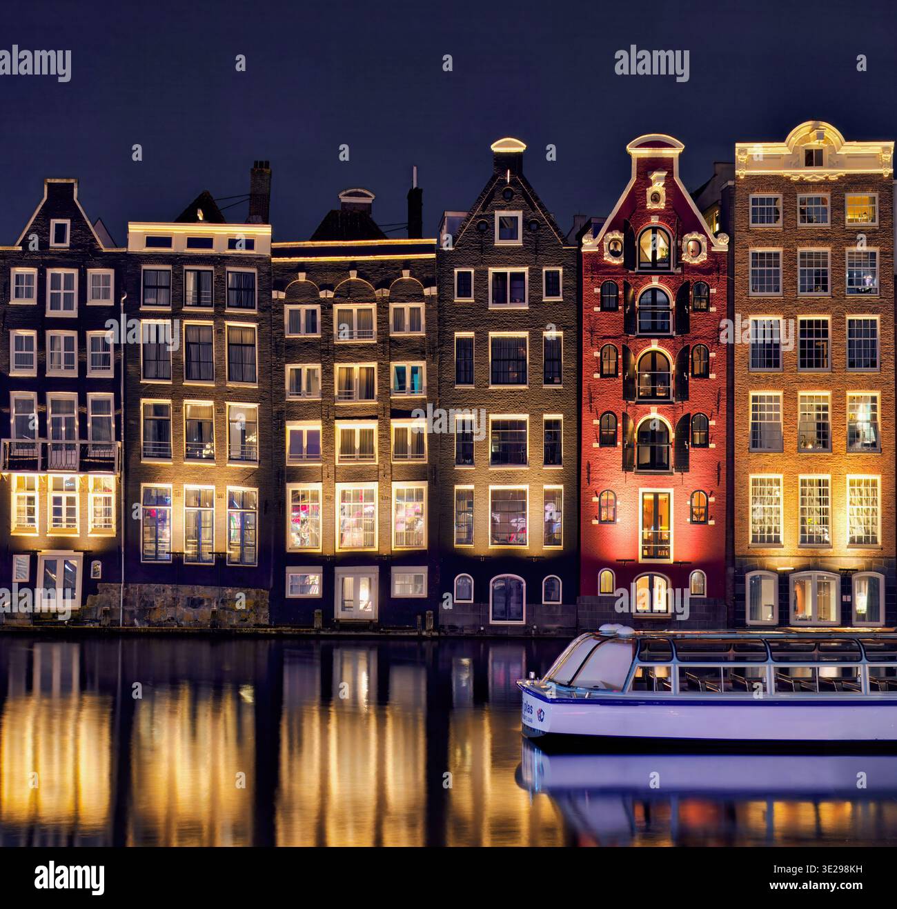 Les maisons Damrak à Amsterdam, aux pays-Bas, créent un kaléidoscope de couleurs et de reflets vibrants, leurs fenêtres formant un patchwork visuel de la vie Banque D'Images