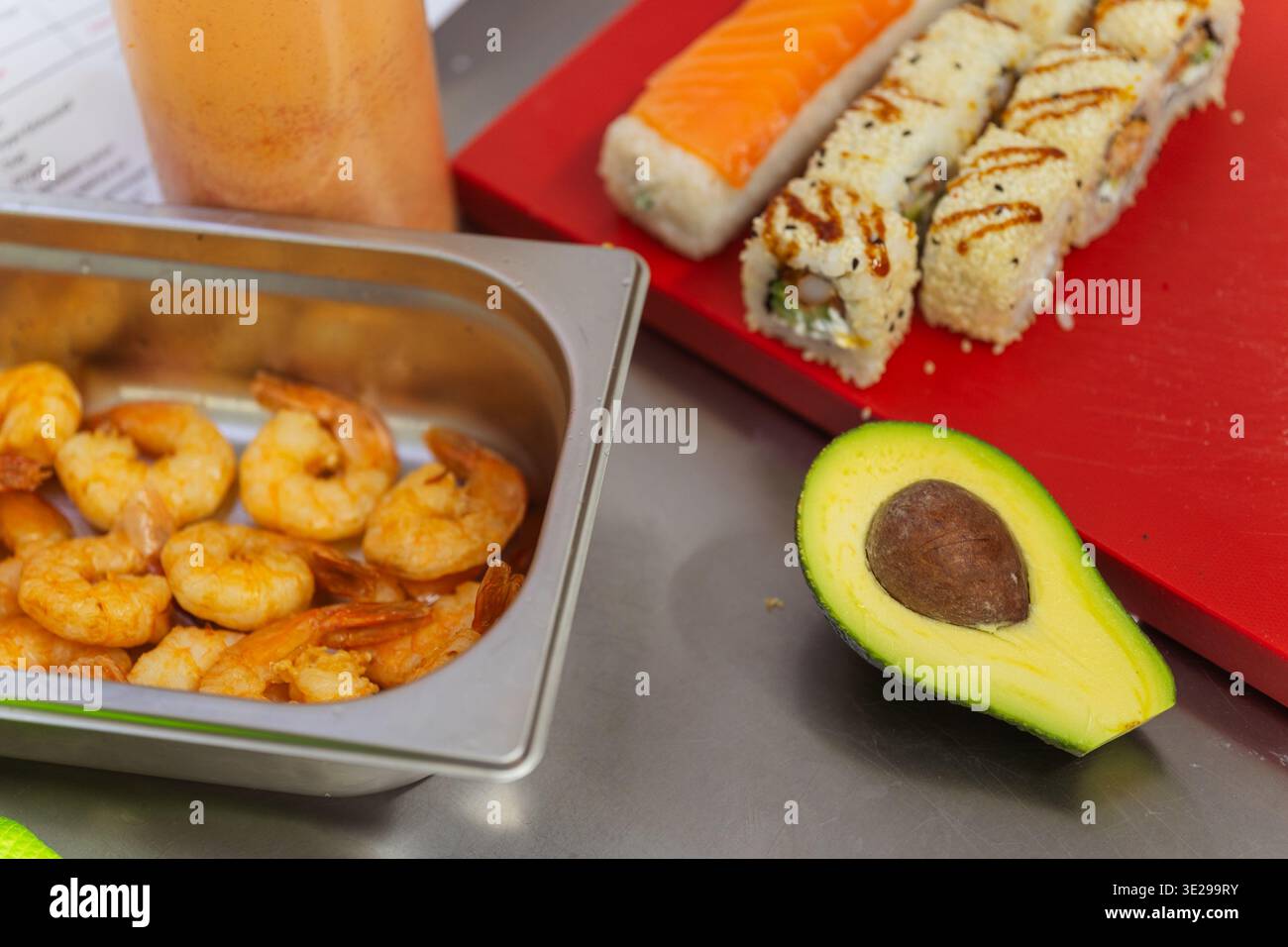 Plateau de crevettes cuites à côté de Sushi et avocat, mise en scène des ingrédients pour le service dans le restaurant Sushi Banque D'Images