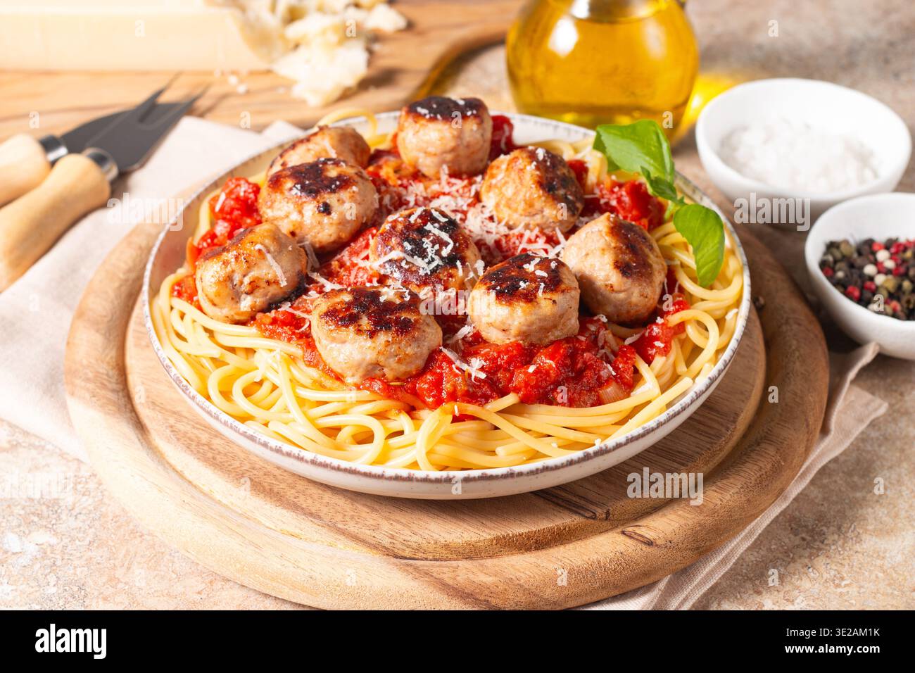 Une assiette de spaghettis classiques garnie de boulettes de viande dorées et d'une riche sauce tomate sur un plat en céramique légère. Banque D'Images