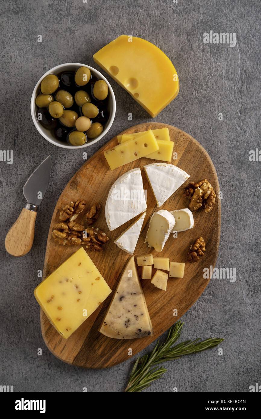 Assortiment de fromages aux noix, olives et romarin Banque D'Images