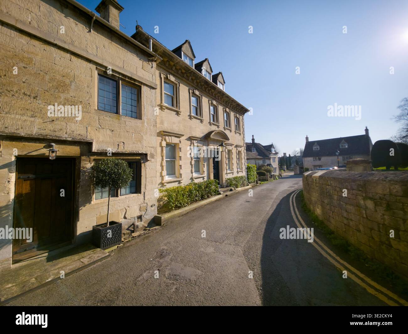 Sunlit Narrow Cotswold Lane avec Honey Stone Houses et Lens Flare, Painswick Area, Gloucestershire, Angleterre - Image de stock capturée avec un smartphone