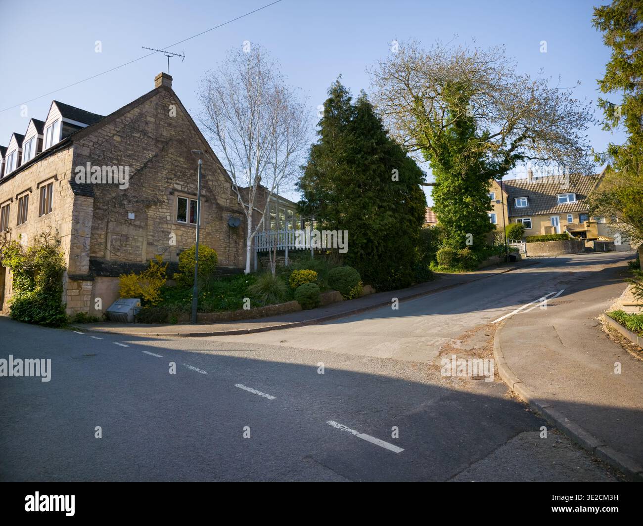 Sunlit Narrow Cotswold Lane avec Honey Stone Houses et Lens Flare, Painswick Area, Gloucestershire, Angleterre - Image de stock capturée avec un smartphone