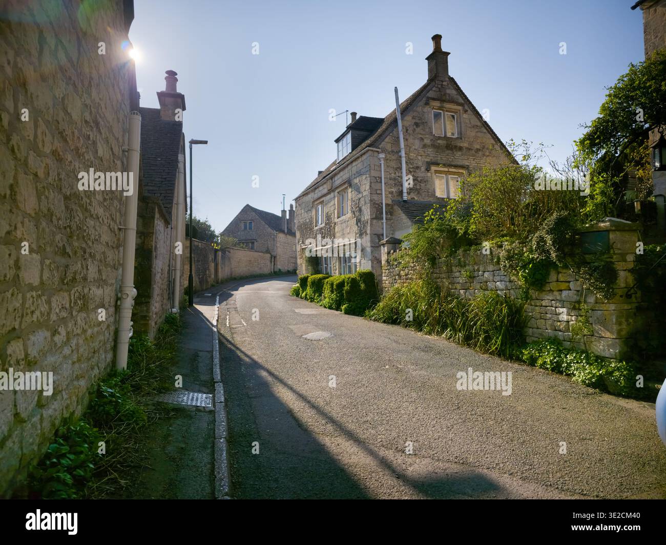 Sunlit Narrow Cotswold Lane avec Honey Stone Houses et Lens Flare, Painswick Area, Gloucestershire, Angleterre - Image de stock capturée avec un smartphone