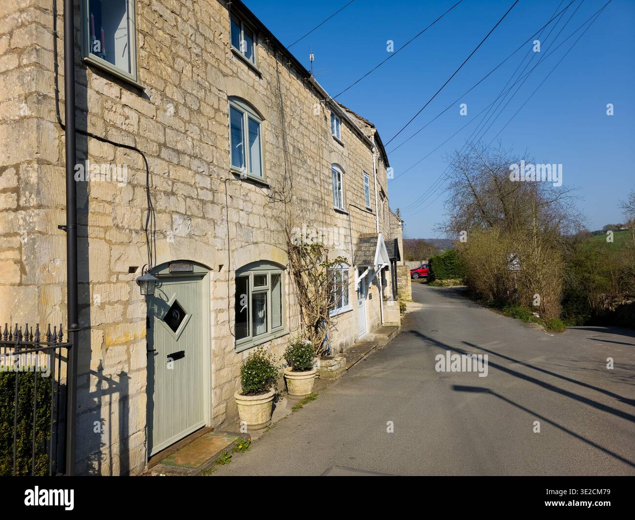 Sunlit Narrow Cotswold Lane avec Honey Stone Houses et Lens Flare, Painswick Area, Gloucestershire, Angleterre - Image de stock capturée avec un smartphone