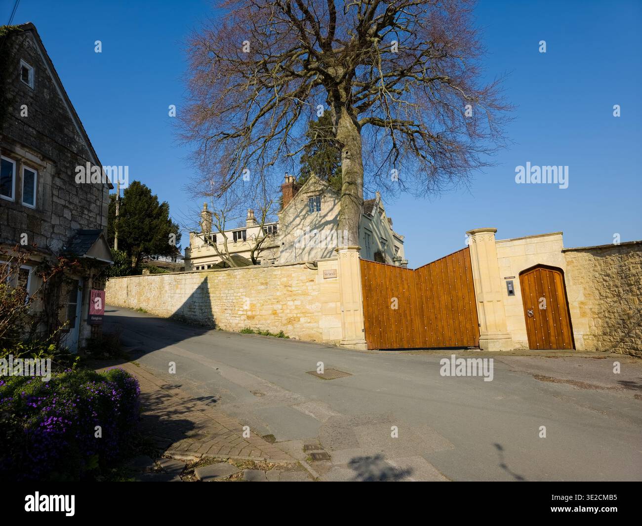 Sunlit Narrow Cotswold Lane avec Honey Stone Houses et Lens Flare, Painswick Area, Gloucestershire, Angleterre - Image de stock capturée avec un smartphone