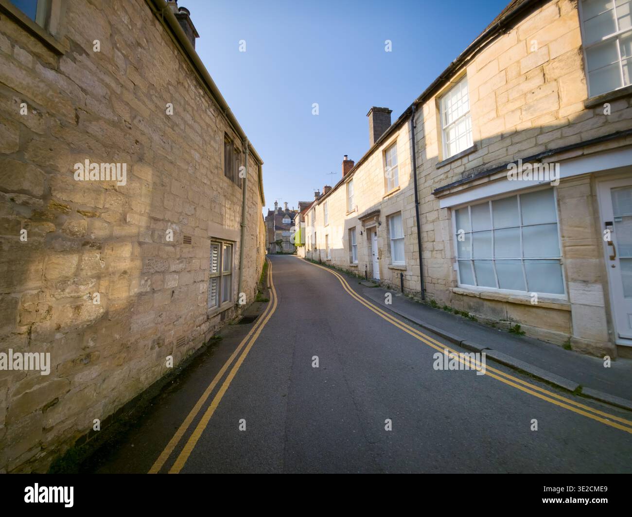 Sunlit Narrow Cotswold Lane avec Honey Stone Houses et Lens Flare, Painswick Area, Gloucestershire, Angleterre - Image de stock capturée avec un smartphone