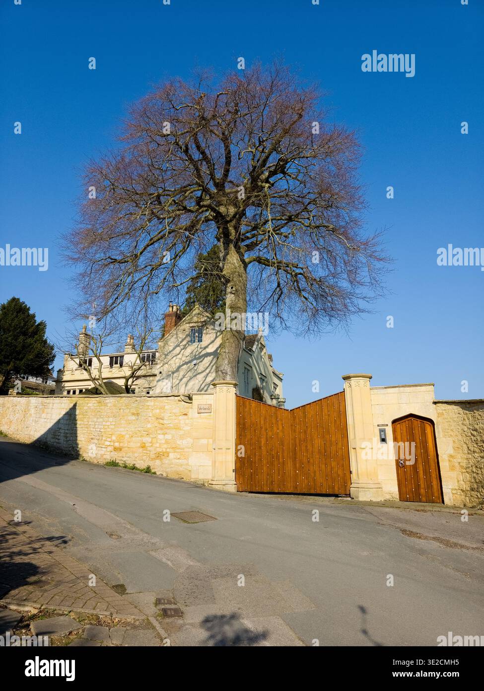 Sunlit Narrow Cotswold Lane avec Honey Stone Houses et Lens Flare, Painswick Area, Gloucestershire, Angleterre - Image de stock capturée avec un smartphone