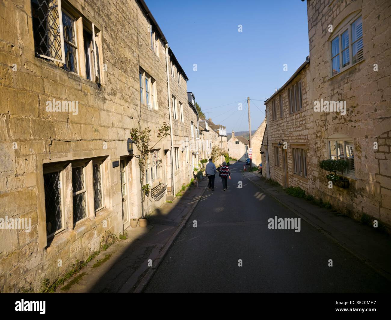 Sunlit Narrow Cotswold Lane avec Honey Stone Houses et Lens Flare, Painswick Area, Gloucestershire, Angleterre - Image de stock capturée avec un smartphone